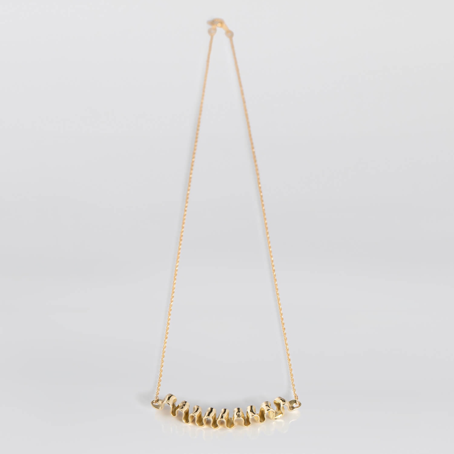 MIRR_WAVE_NECKLACE_LAYING_BRASS_WEB.jpg